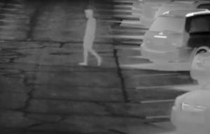 Nighttime heat mapping surveillance footage in parking lot with silhouette of person walking.