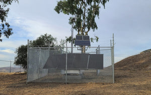 Vorp Solar surveillance skid with bullet cameras placed in chain link fence with barbed wire.